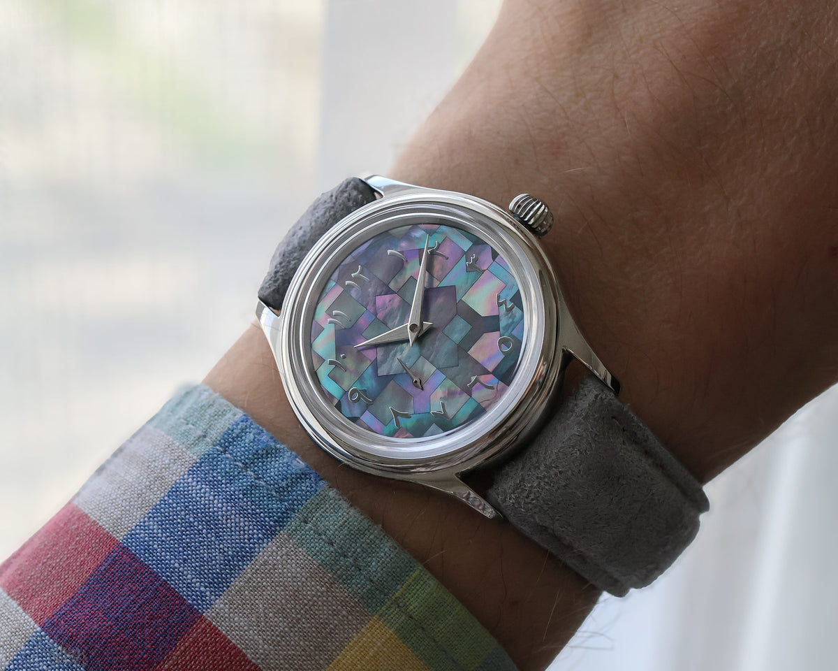 L’Artisan Arabic Mosaic on its grey suede strap